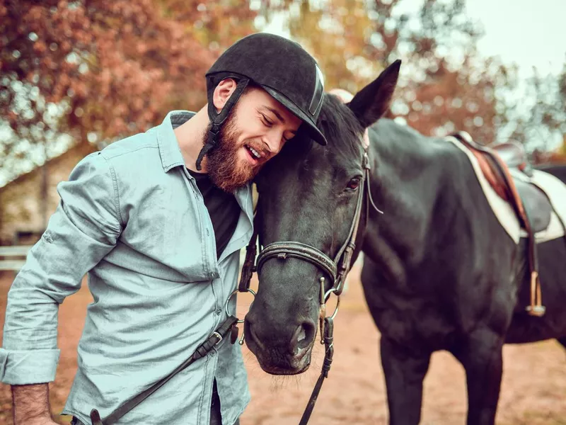 Modern Male Jockey Embracing Horse