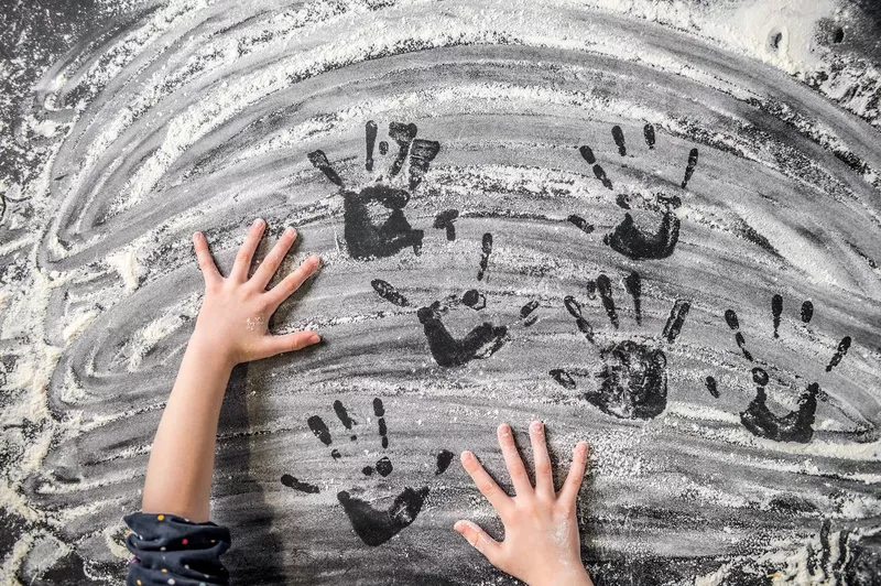 Child's hands on the flour